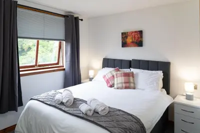 a bedroom with a bed with towels on it at Bothwell Court Apartments in Dunfermline