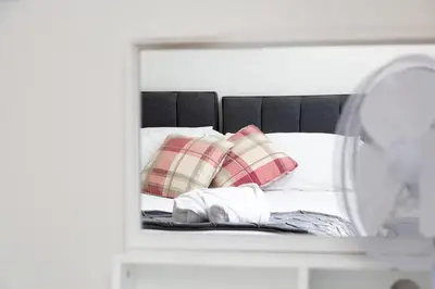 a mirror reflection of a bed with pillows at Bothwell Court Apartments in Dunfermline