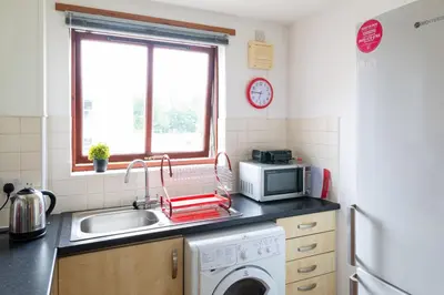 a kitchen with a sink and a washing machine at Bothwell Court Apartments in Dunfermline