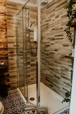 a shower in a bathroom with wooden walls at Luxurious mountain retreat lodge Hunters Quay in Dunoon