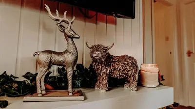 a statue of a reindeer and a candle on a shelf at Luxurious mountain retreat lodge Hunters Quay in Dunoon