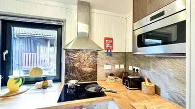 a kitchen with a sink and a stove top oven at Luxurious mountain retreat lodge Hunters Quay in Dunoon