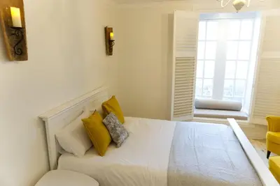 a bedroom with a bed with yellow pillows and a window at Stunning & unique apt in Culross in Culross