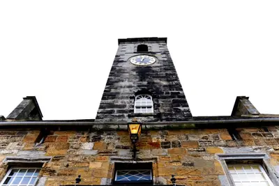 a clock tower on top of a building with windows at Stunning & unique apt in Culross in Culross