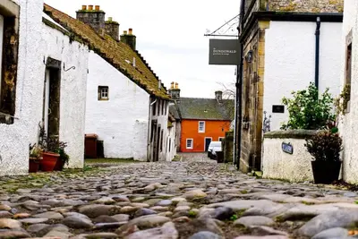 a cobblestone street in a village with buildings at Stunning & unique apt in Culross in Culross