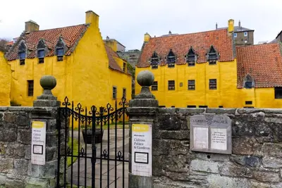 a yellow building with a gate in front of it at Stunning & unique apt in Culross in Culross