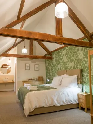 a bedroom with a bed with a green wall at Coach House Ratho Park Steading in Ratho
