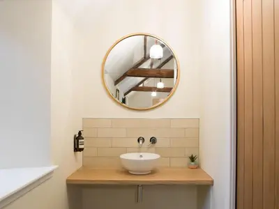 a bathroom with a sink and a mirror at Coach House Ratho Park Steading in Ratho