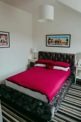 a bedroom with a large bed with a red blanket at Dawn Break Guest House in Largs