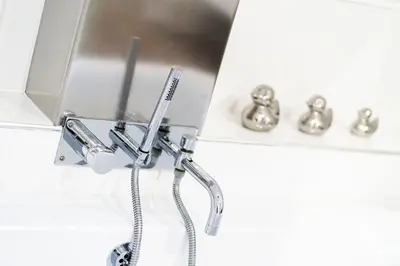 a bathroom with a shower head and a sink at Cross Road Apartment in Paisley