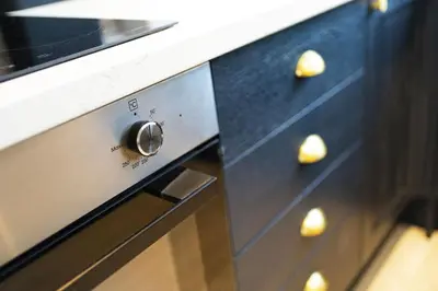 a close up of an oven with gold knobs at Cross Road Apartment in Paisley