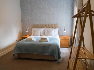 a bedroom with a bed with two towels on it at Stunning Edinburgh 1820s stables converted studio in Edinburgh