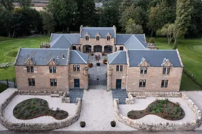 an aerial view of a large house with a yard at Stunning Edinburgh 1820s stables converted house in Ratho