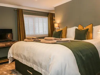 a bedroom with two large beds with a television at Feus Holiday Cottage in Auchterarder