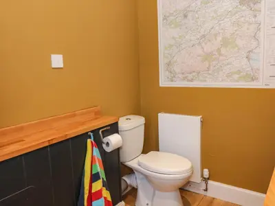 a bathroom with a toilet and a map on the wall at Feus Holiday Cottage in Auchterarder