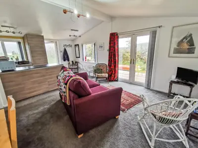 a living room with a purple couch and a tv at Kelpie in Lochgilphead