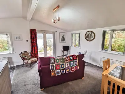 a living room with a couch and some windows at Kelpie in Lochgilphead