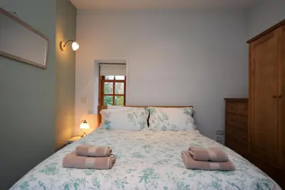 a bedroom with a bed with two towels on it at Kevington Cottage in Hunters Quay