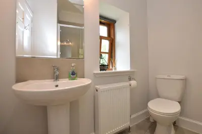 a white bathroom with a sink and a toilet at Kevington Cottage in Hunters Quay