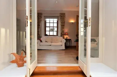 a living room with a white couch and a window at Kevington Cottage in Hunters Quay