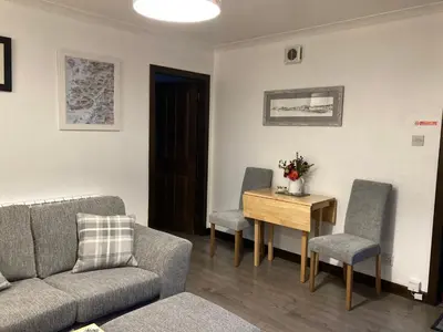 a living room with a couch and a table and chairs at Machrie Cottage, Oban, in Oban