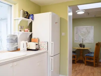 a kitchen with a white refrigerator and a table at Puddingstone Cottage in Gartmore