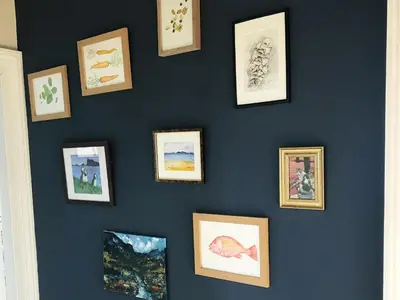 a wall of framed pictures on a blue wall at Grand top floor apartment in the Royal Bank House in Maybole