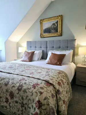 a bedroom with a large bed and a painting on the wall at Castleblair Snug - Entire Flat in Dunfermline in Dunfermline