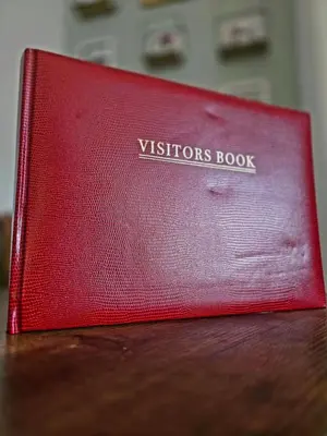 a red book sitting on top of a wooden table at Castleblair Snug - Entire Flat in Dunfermline in Dunfermline