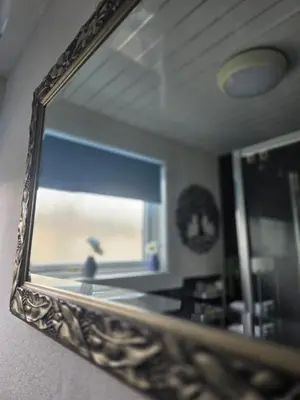 a mirror on a wall with a reflection of a room at Castleblair Snug - Entire Flat in Dunfermline in Dunfermline