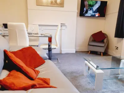 a living room with a white couch and a table at Carvetii - Vincent House - Large 3 bedroom apartment with on-site parking in Fife