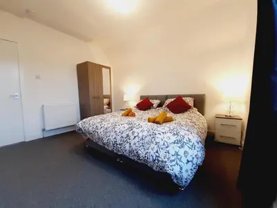 a bedroom with a large bed with red pillows at Carvetii - Vincent House - Large 3 bedroom apartment with on-site parking in Fife