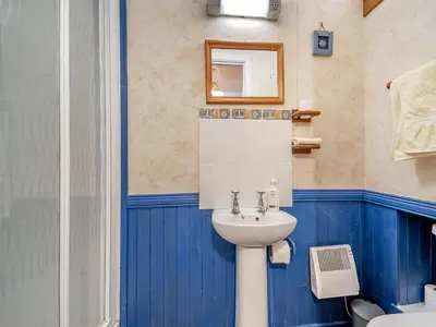 a blue bathroom with a sink and a toilet at The Bothy - Uk37414 in Bunessan
