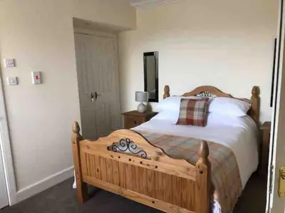 a bedroom with a large bed with a wooden frame at Allerton - Victorian Character Home in Stirling in Stirling