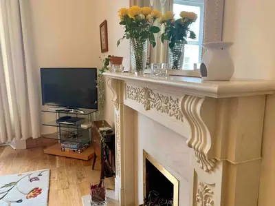 a living room with a fireplace and a television at Allerton - Victorian Character Home in Stirling in Stirling