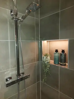a shower with two bottles on a shelf in a bathroom at Station View, Dunblane in Dunblane