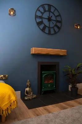 a room with a clock on the wall and a fireplace at Station View, Dunblane in Dunblane