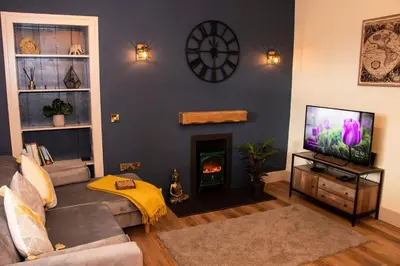 a living room with a couch and a fireplace at Station View, Dunblane in Dunblane