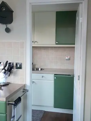 a kitchen with green and white cabinets and a sink at Willow Lodge Auchterarder in Auchterarder