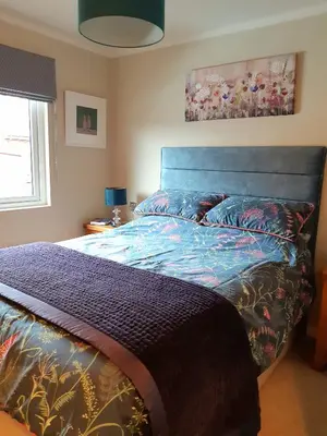 a bed with a blue headboard in a bedroom at Willow Lodge Auchterarder in Auchterarder