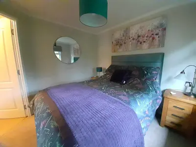 a bedroom with a purple bed and a mirror at Willow Lodge Auchterarder in Auchterarder