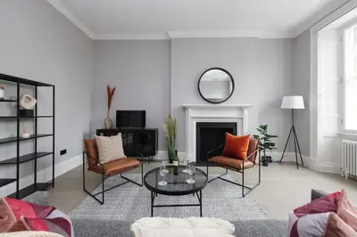 a living room with a table and chairs at JOIVY Luxurious Apt on Notable George Street in Edinburgh