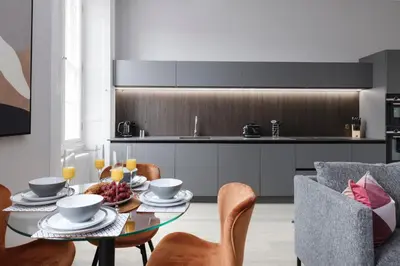 a kitchen and dining room with a table and chairs at JOIVY Luxurious Apt on Notable George Street in Edinburgh