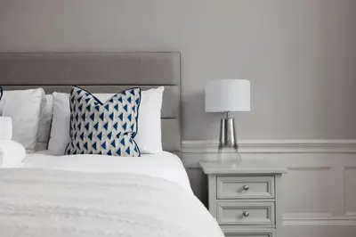 a bedroom with a bed and a night stand with a lamp at JOIVY Luxurious Apt on Notable George Street in Edinburgh