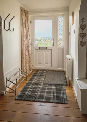 a hallway with a door with a window and a rug at Castle View - Home from Home in Stirling