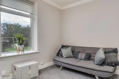 a living room with a couch and a window at The Garden Flat, Loch Lomond in Alexandria