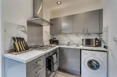 a kitchen with a washing machine and a washer at The Garden Flat, Loch Lomond in Alexandria