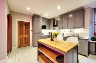 a kitchen with a counter with flowers in a vase at Stylish & Spacious 3 Bedroom Apt in Finnieston, West End in Glasgow