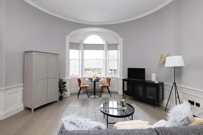 a living room with a couch and a table at JOIVY Modern Studio in New Town, on Historic George Street in Edinburgh