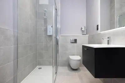 a bathroom with a shower and a toilet and a sink at JOIVY Modern Studio in New Town, on Historic George Street in Edinburgh